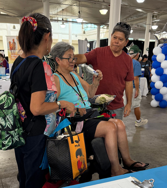 A person in a wheelchair with two caregivers